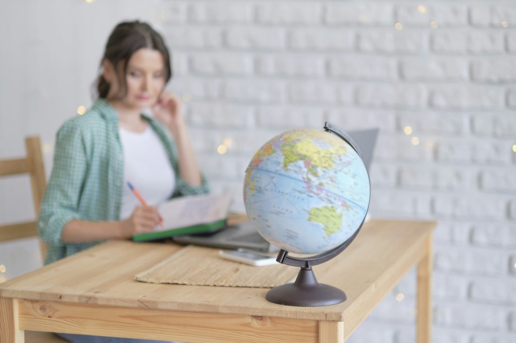 mixed-race business woman globe to convey she works for an international company.