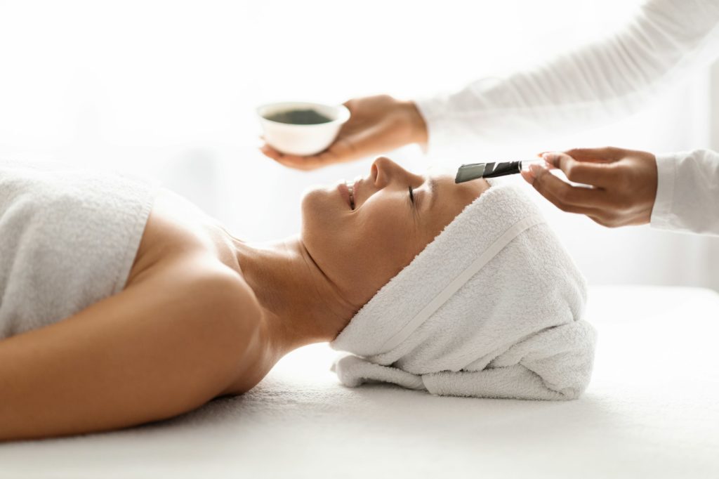 Skincare Concept. Cosmetologist doctor applying mask to middle aged woman in spa