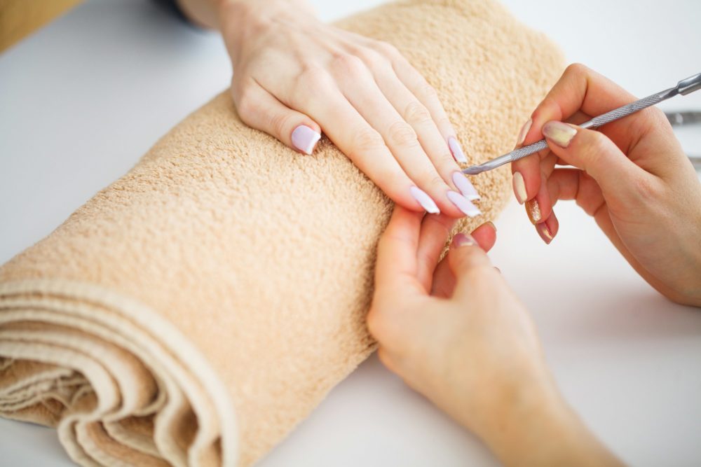 SPA manicure. Woman in a nail salon receiving a manicure by a beautician