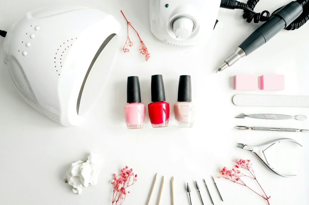 Tools of a manicure set on a white background. Ultraviolet lamp and manicure sander for gel polish.