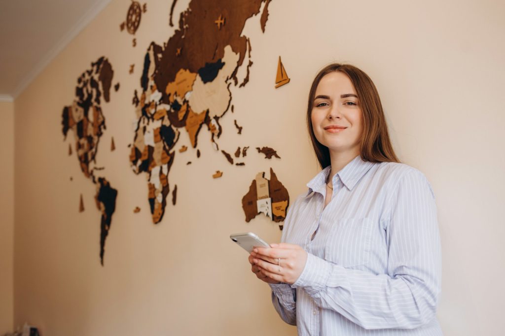 Young female travel agent consultant in tour agency phone call